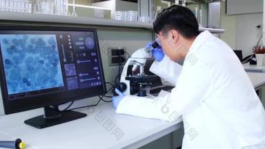 科学家在实验室用显微镜及电子屏进行观察